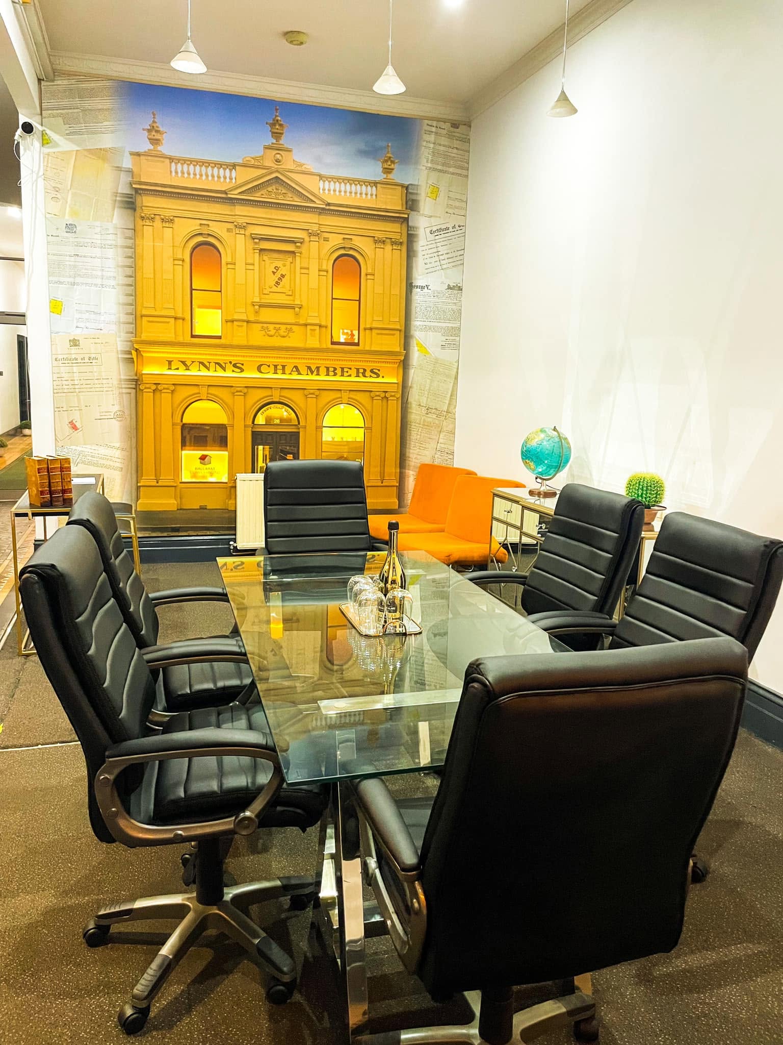 A conference table with leather chairs set up for meetings inside Lynn's Chambers